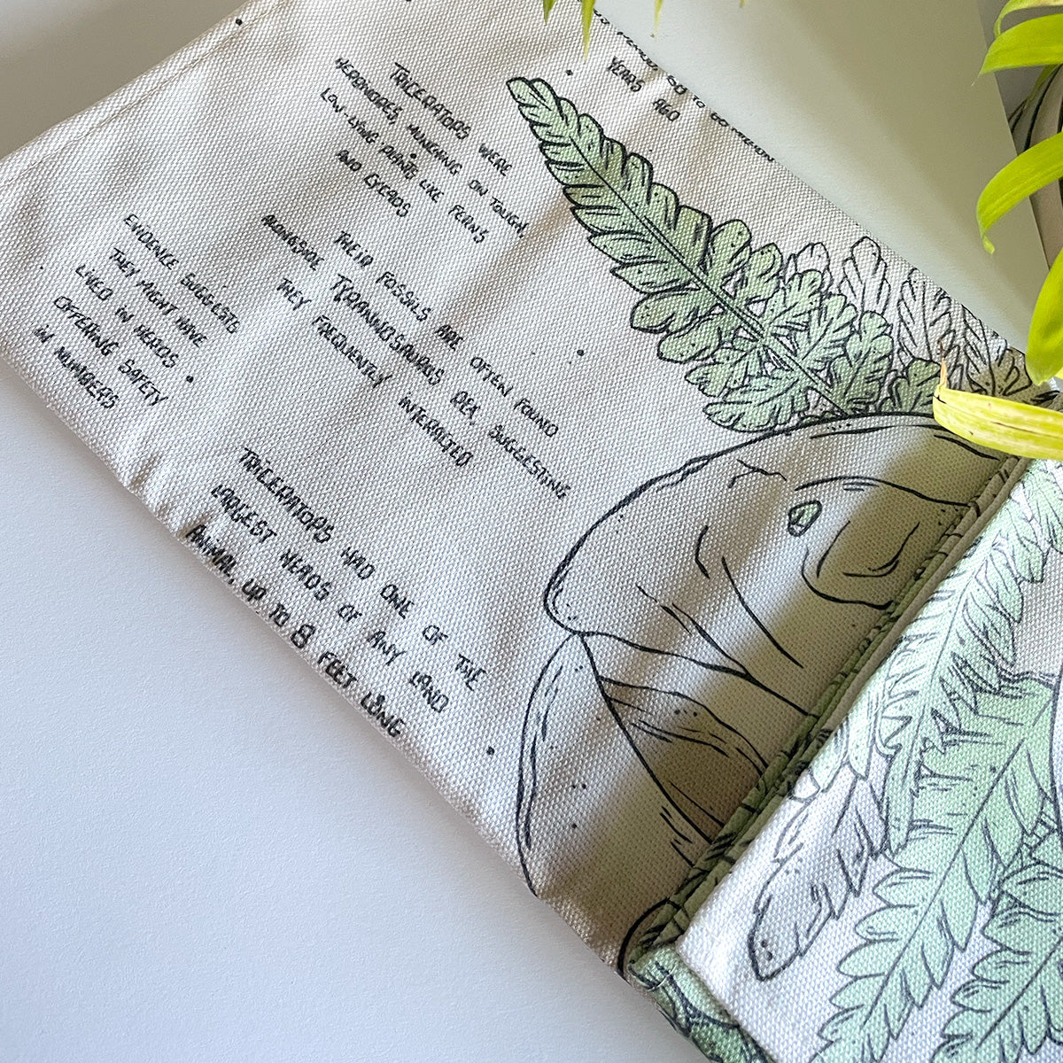 manchester and york museums gift shop triceratop dinosaur tea towel, folded illustrated fabric, curious facts