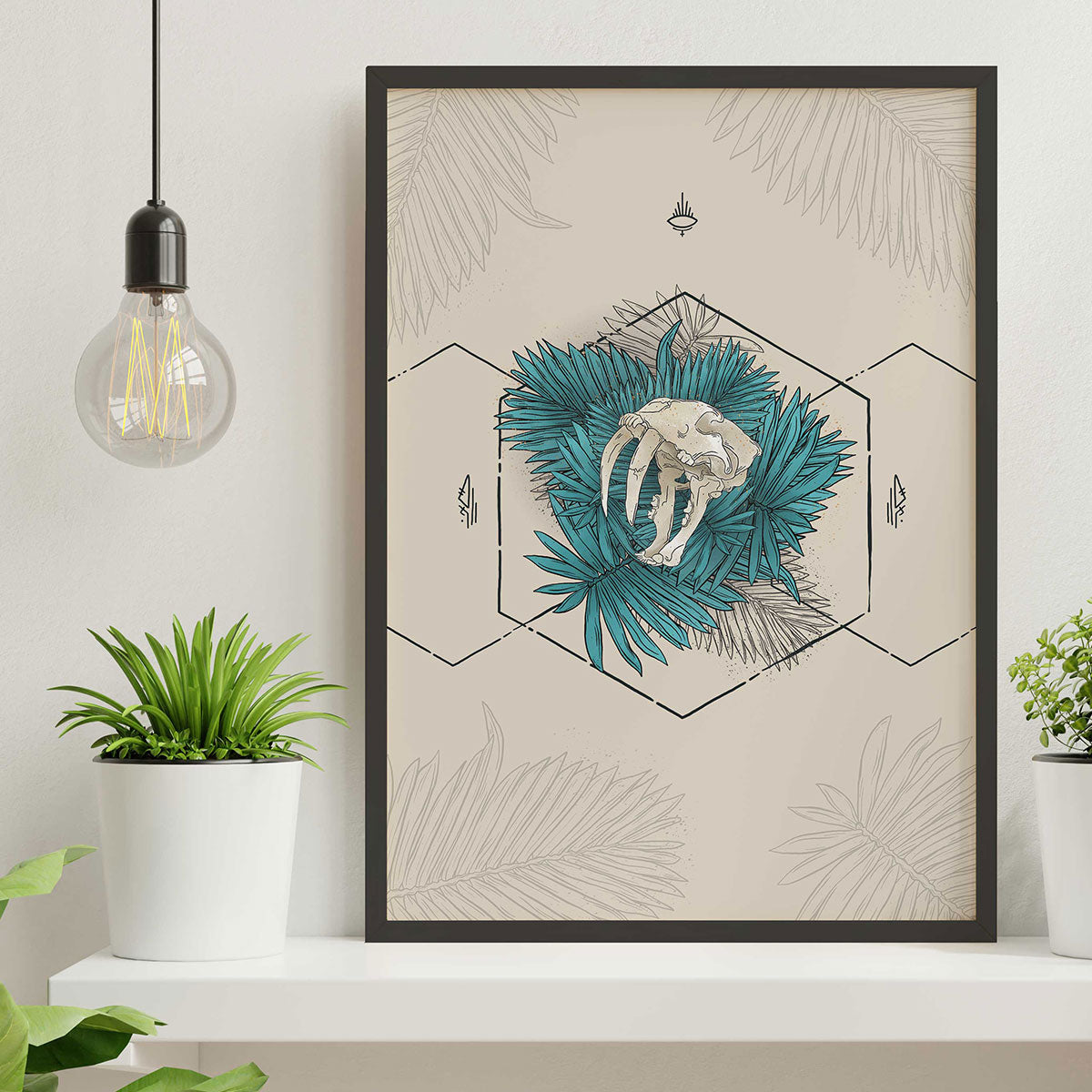 Art print framed sitting on white shelf, design shows outlined hexagons black lines, leaves inside with sabertooth skull showing teeth in the centre. Light cream background