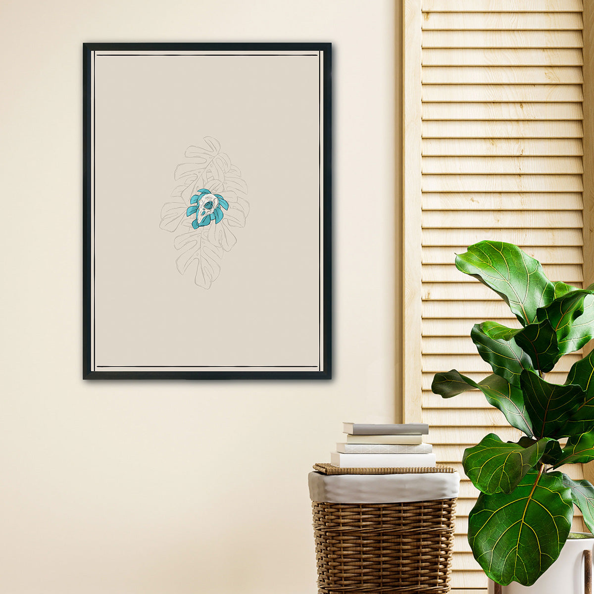 art print hanging on room with ficus plant to the right, design of single bird skull tiny monstera leaves behind, bigger outlined monstera leaves watermark merging with background in cream, thin black lines as borders