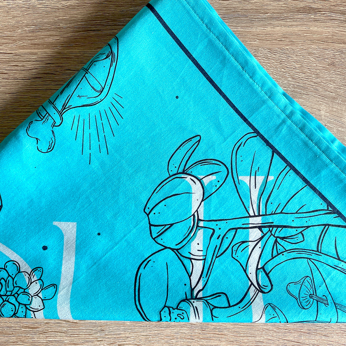 Printed turquoise bandana featuring a unique design with earth, crystals, plants, and bones. Perfect for nature lovers, bohemian fashion, or occult enthusiasts. 